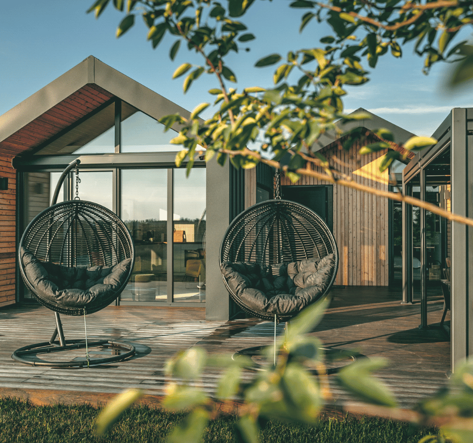 stuga modern tiny house gefotografeerd tussen struiken door