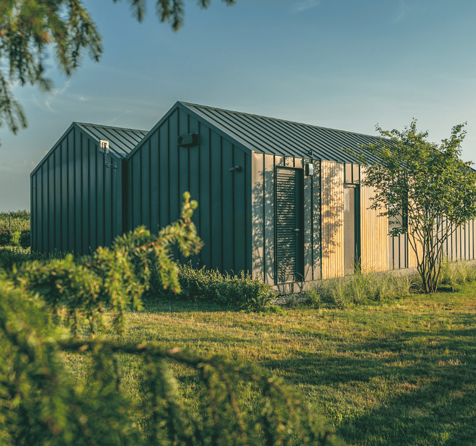 ahterkant van een modern en luxe tiny house, buiten, gras, bomen