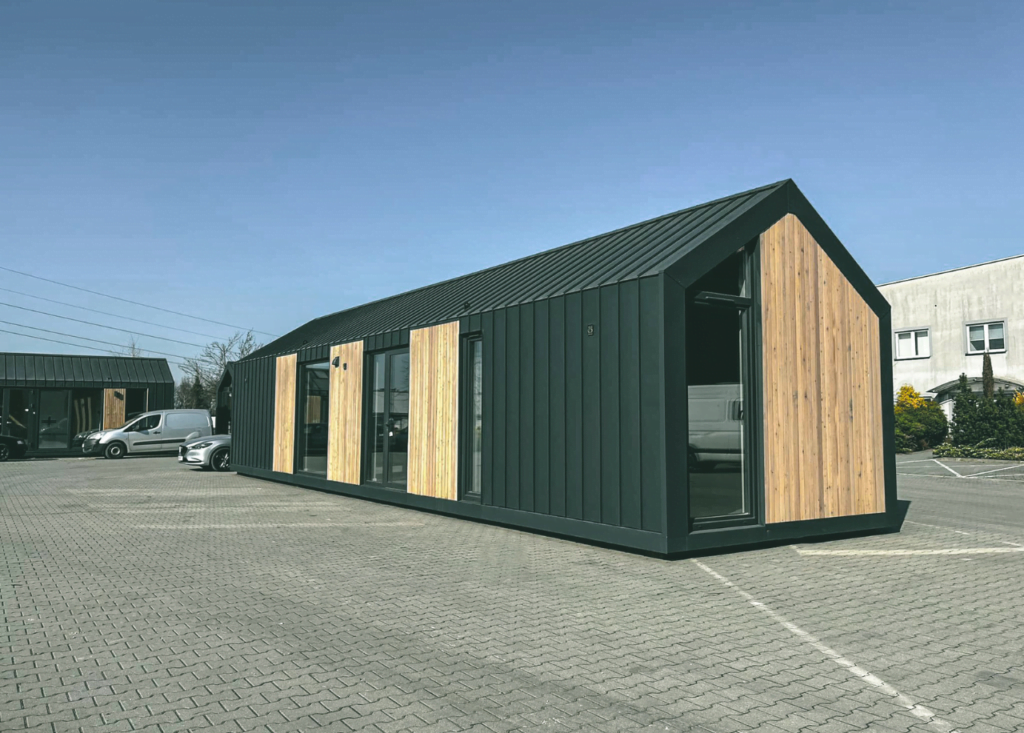 tiny house op parkeerplaats, blauwe lucht, extra groot huis, te koop