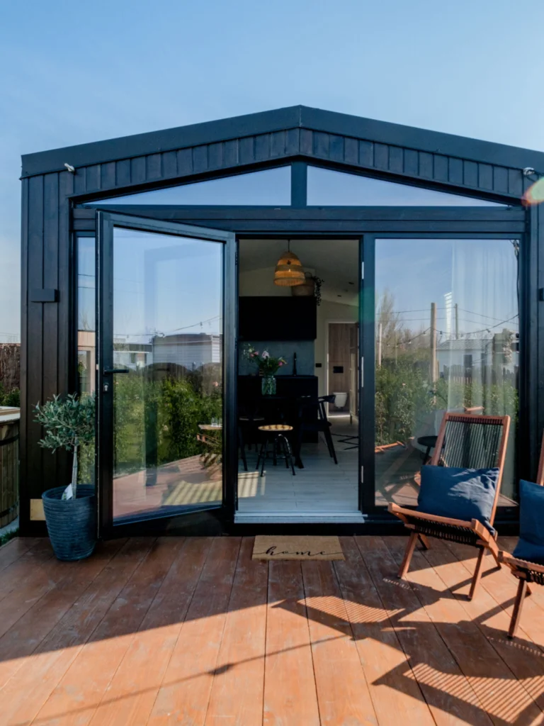 Uitnodigende houten terras met een eethoek in een minimalistische stijl, gelegen in een kleine, zonnige tuin.