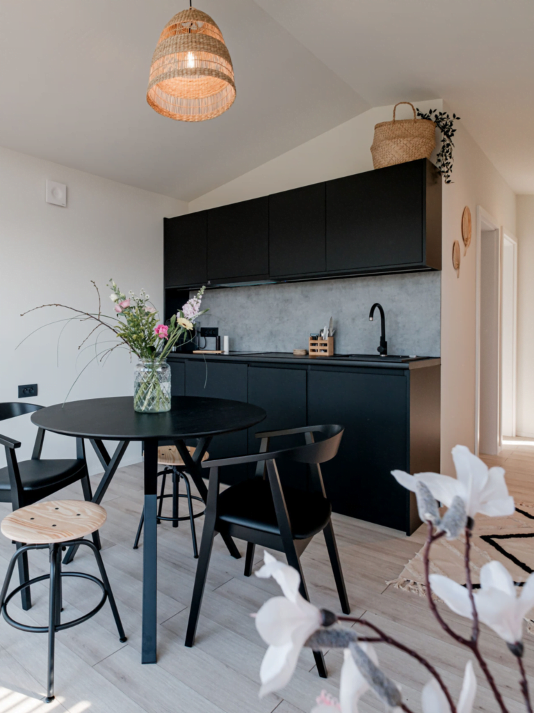 Modern interieur van een compact huis met een strakke keuken, eettafel en bloemdecoraties