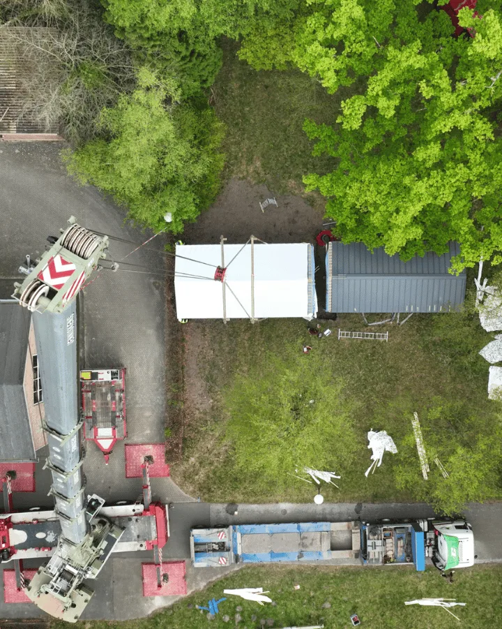 Prefab Tiny House wordt met hijskraan op fundering geplaatst op locatie in het groen