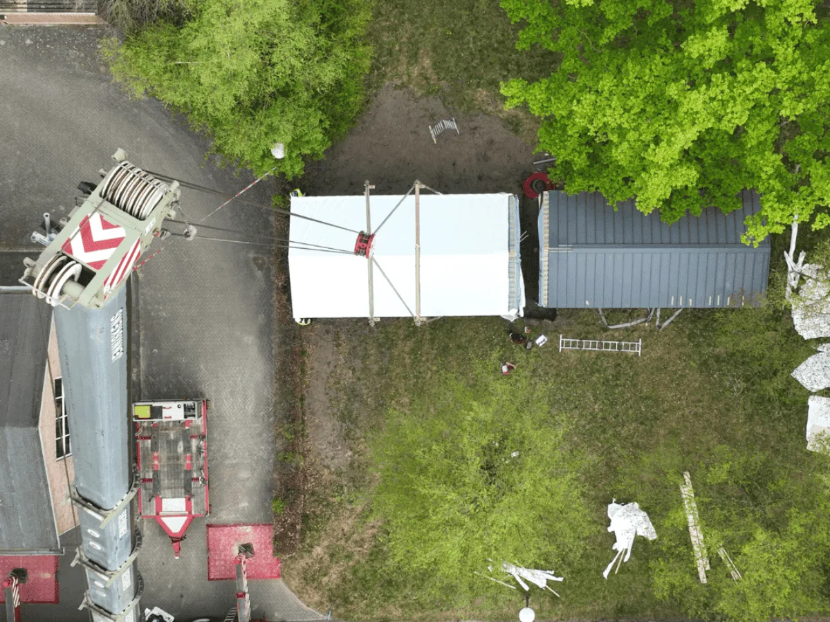 Dronebeeld van de plaatsing van een Tiny House naast een bestaande woning
