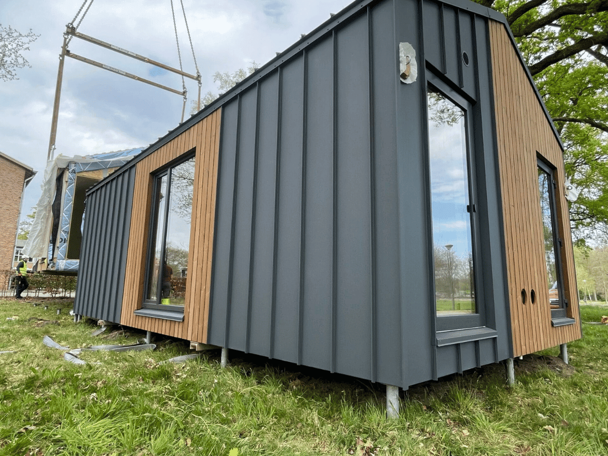 Modern Tiny House met houten gevelbekleding en donkere metalen afwerking op locatie